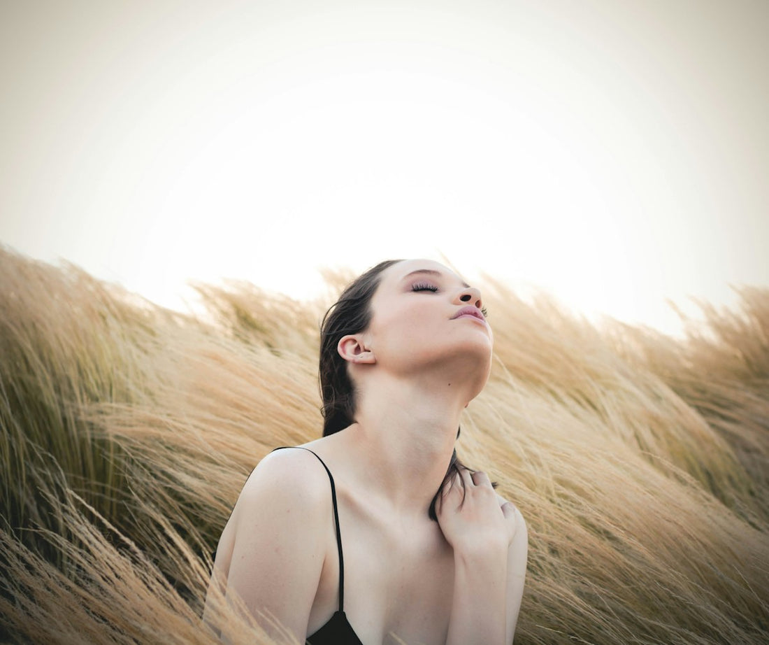 Woman breathing fresh air outdoors among tall grass