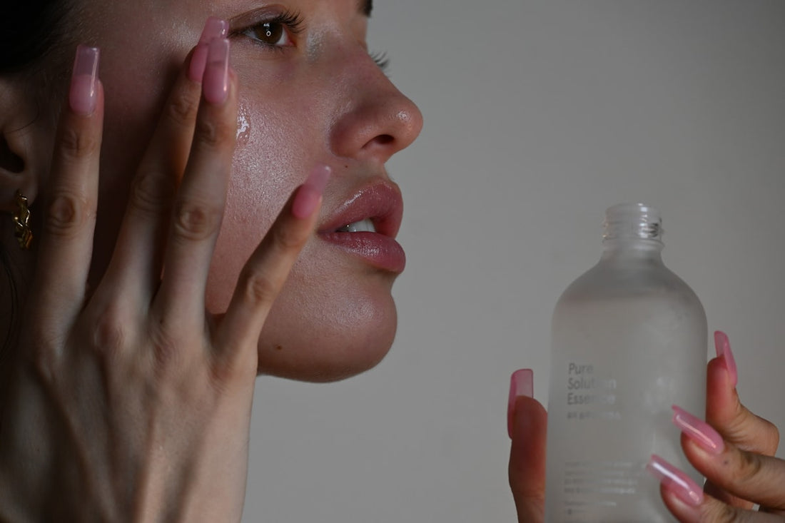 Person applying skincare lotion to face